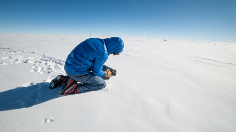 Mann mit blauer Jacke im Schnee