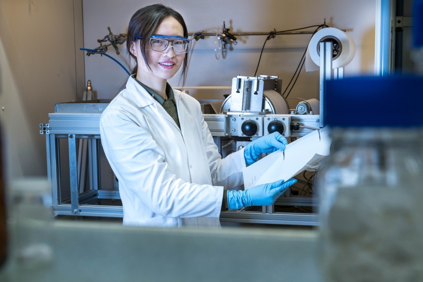 Zhenzhen Zhang präsentiert die Herstellung der Membran mit der institutseigenen Membranziehmaschine (im Hintergrund)