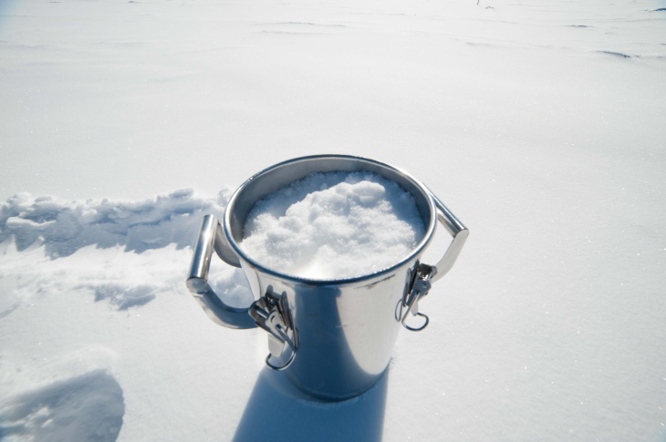 Eimer im Schnee mit Schnee gefüllt